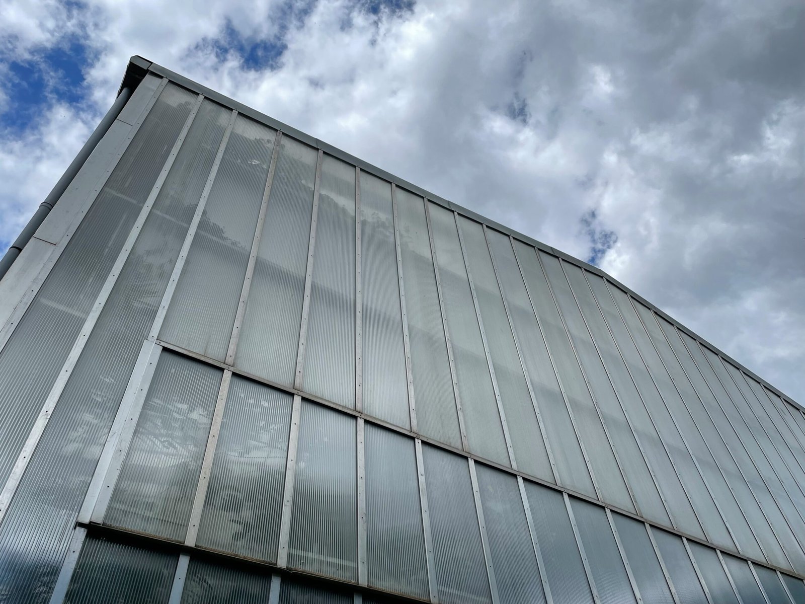 a tall building with lots of windows under a cloudy sky